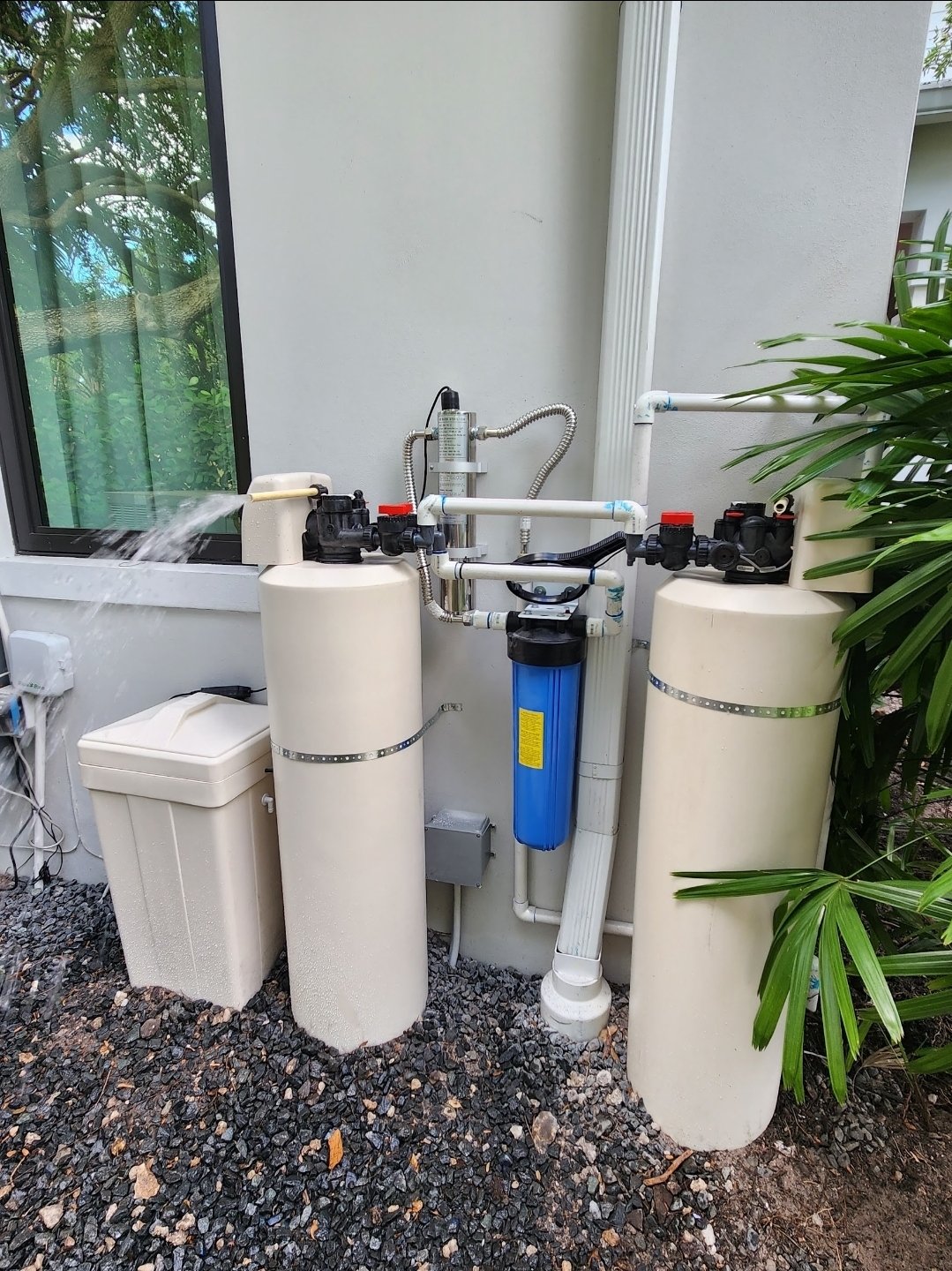Professionally installed dual-tank water filtration system with UV light and prefilter at a South Florida home